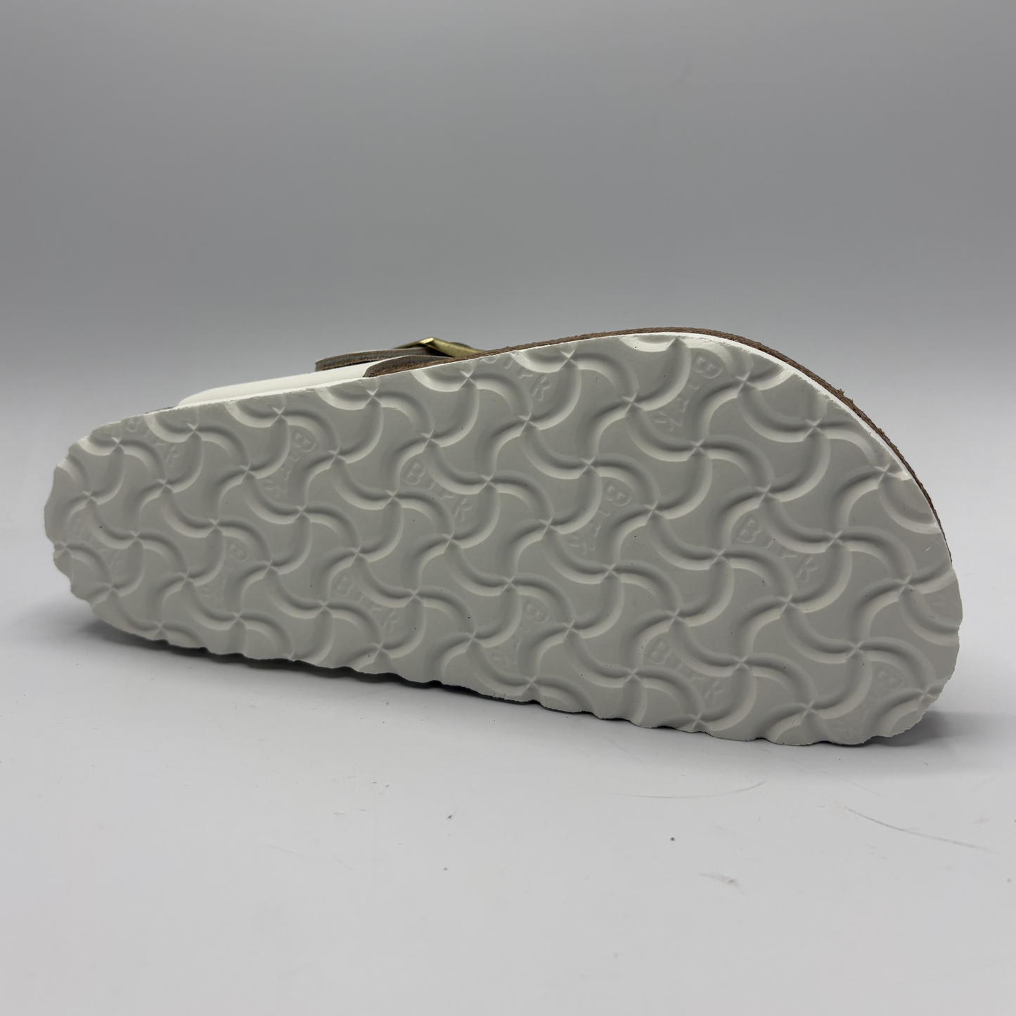 Close-up of a sandal sole with wavy pattern on a gray background