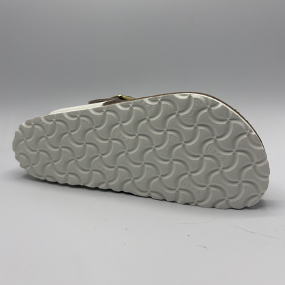 Close-up of a sandal sole with wavy pattern on a gray background