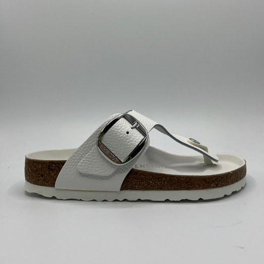 Right facing view of a white leather thong sandal with a big silver buckle on the adjustable strap. Featuring a contoured cork footbed with a leather lining.