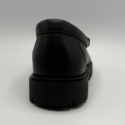 A black leather loafer shown from a rear three-quarter angle, featuring a thick black platform sole, photographed on a neutral light gray background.