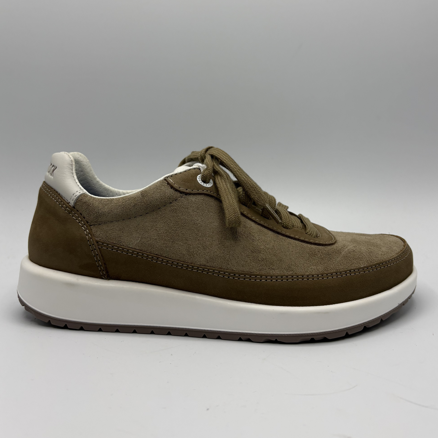 Brown suede shoe with white sole on a gray background