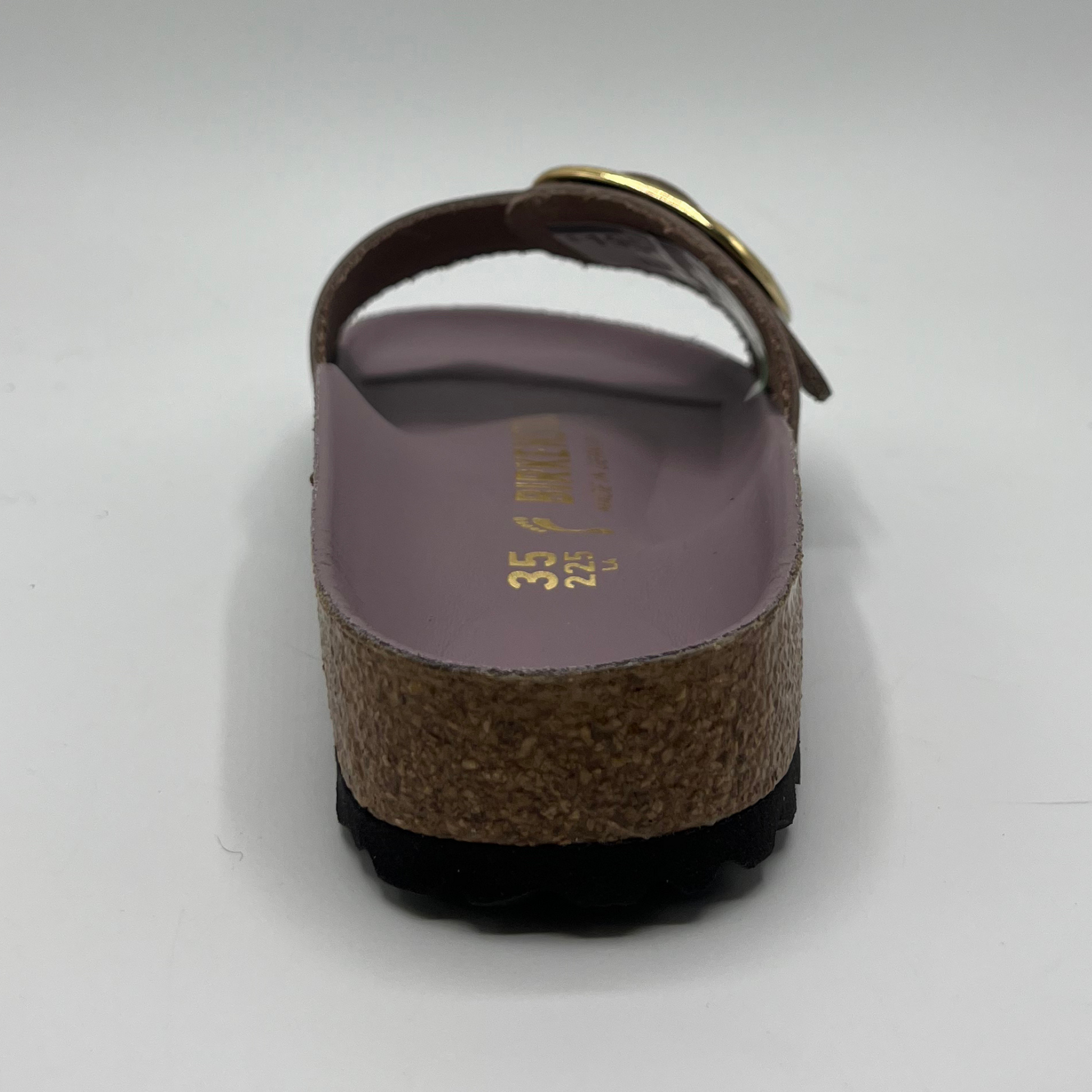 Back view of a faded purple slip on sandal with a big gold buckle on the strap. Featuring a lined,  contoured cork footbed