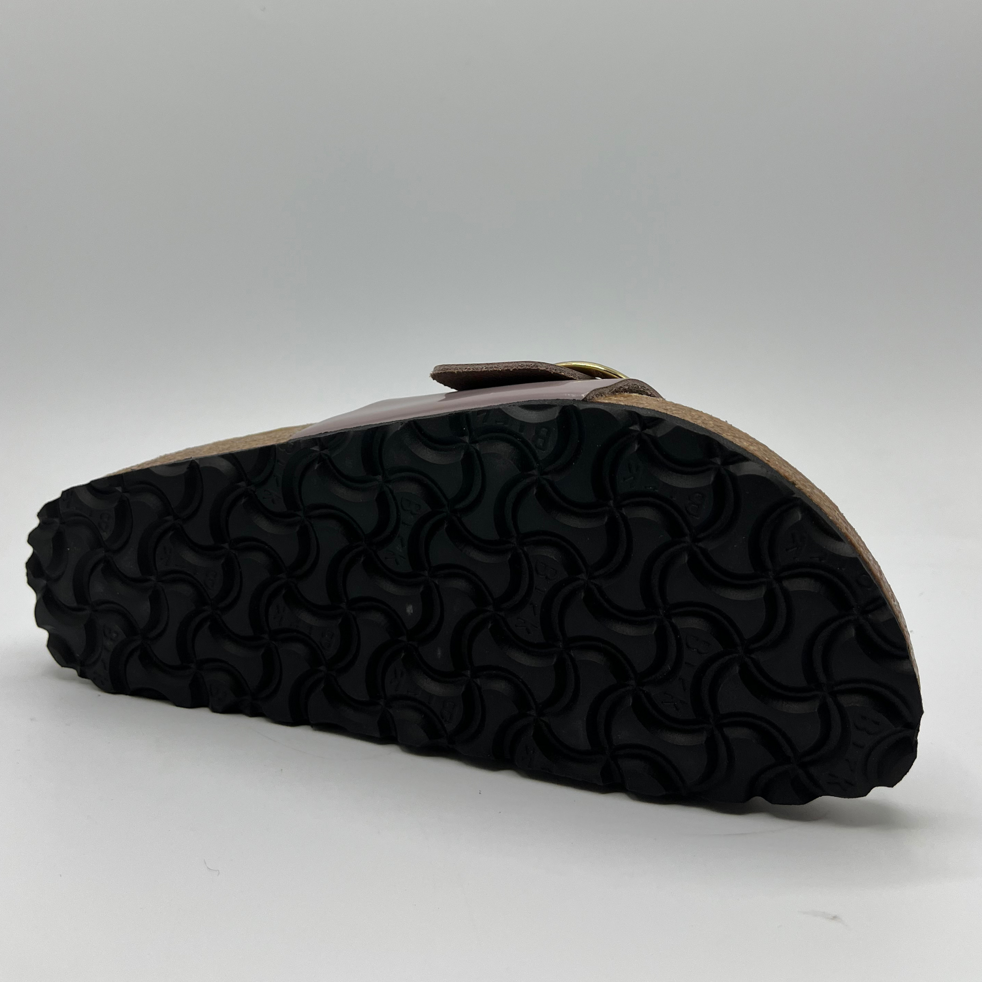 Bottom view of a faded purple slip on sandal with a big gold buckle on the strap. Featuring a lined,  contoured cork footbed