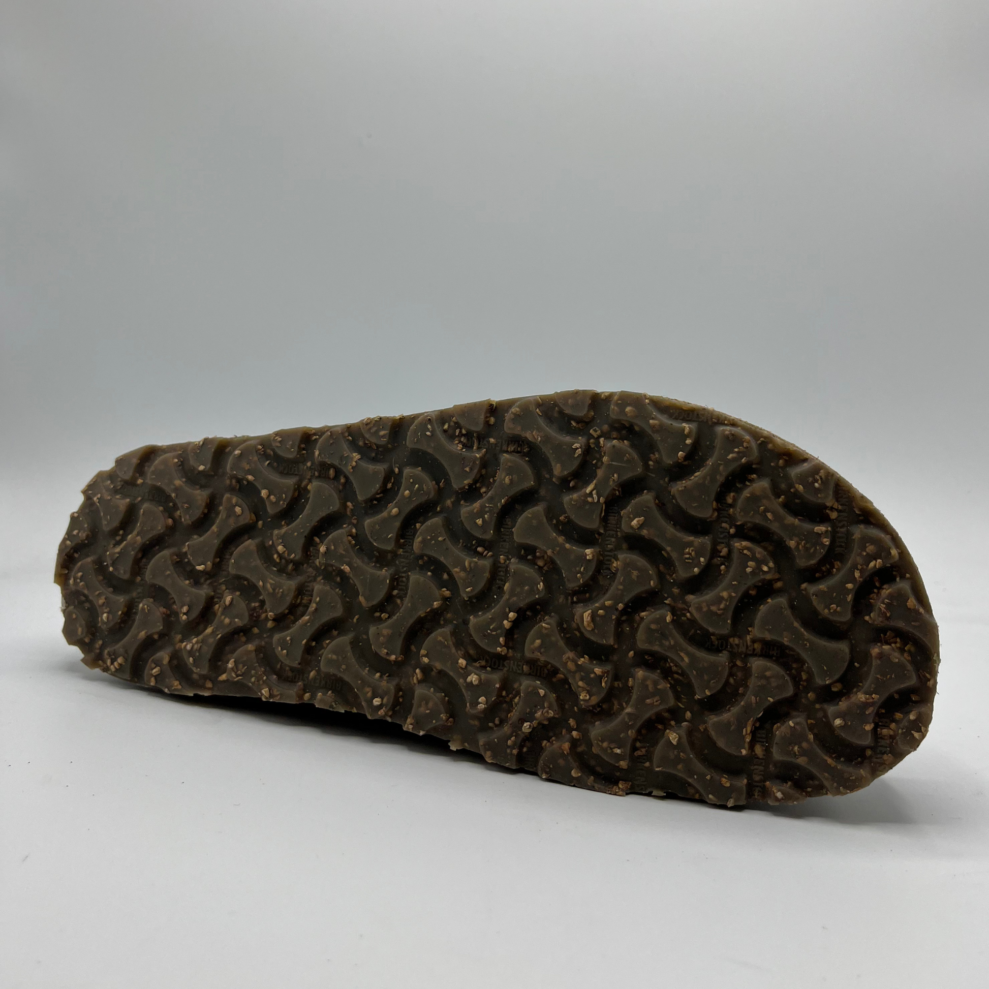 Brown sole of a shoe with tread pattern on a gray background