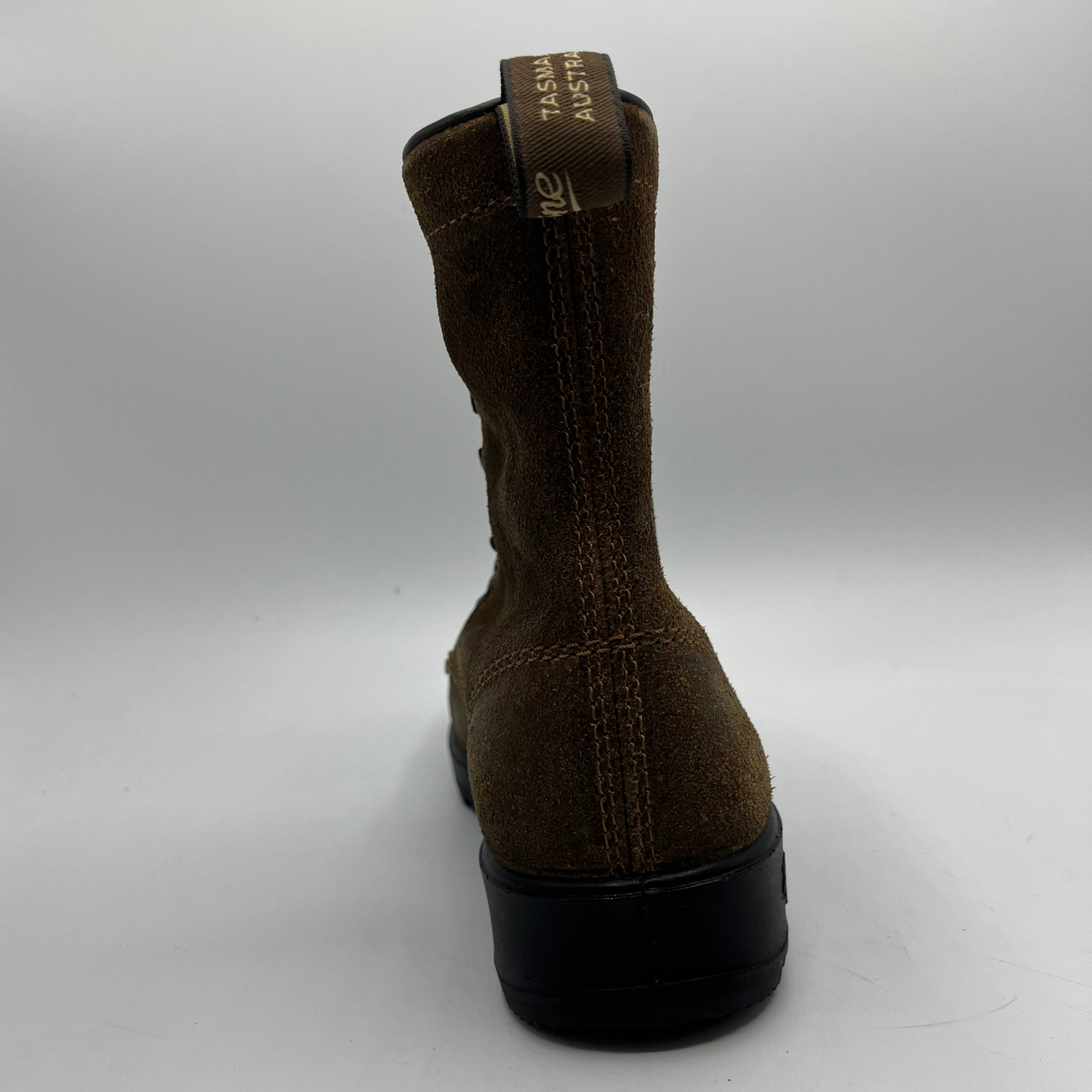 Brown boot with a branded pull tab on a white background