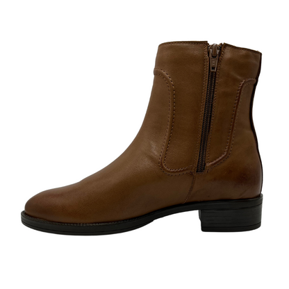 Left facing view of rich tan leather short boot with a low block heel and side zipper closure