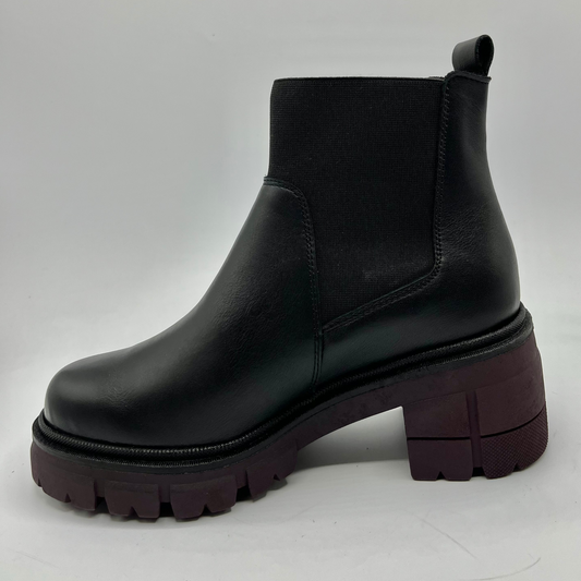 Black leather boot with a thick sole on a light gray background