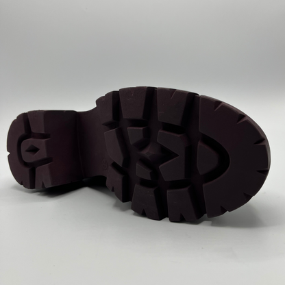 Close-up of a dark brown rubber sole on a light gray background