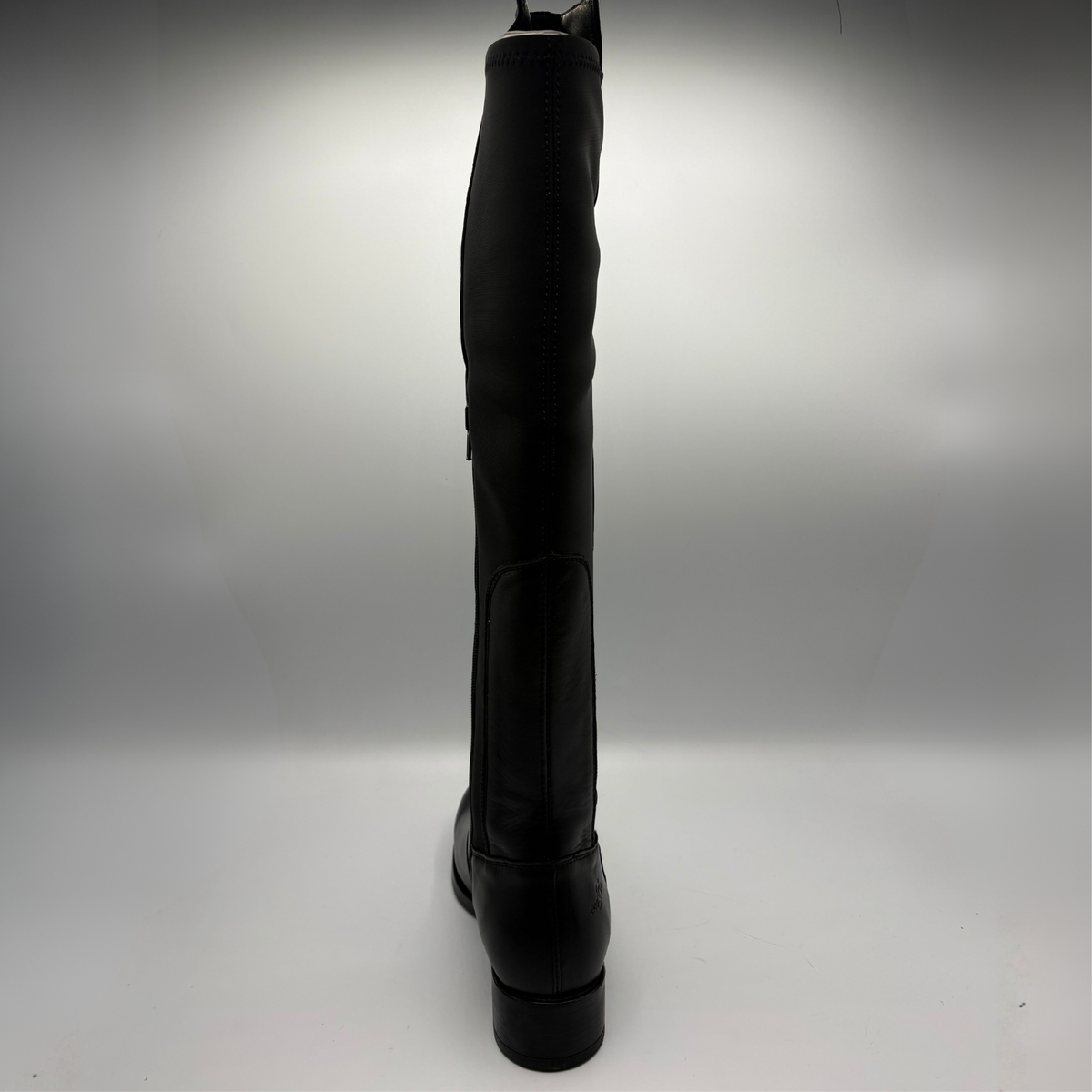 Back view of a black leather boot with an elasticated back panel on a white background