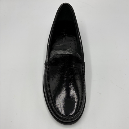 Black leather loafer shoe on a light gray background