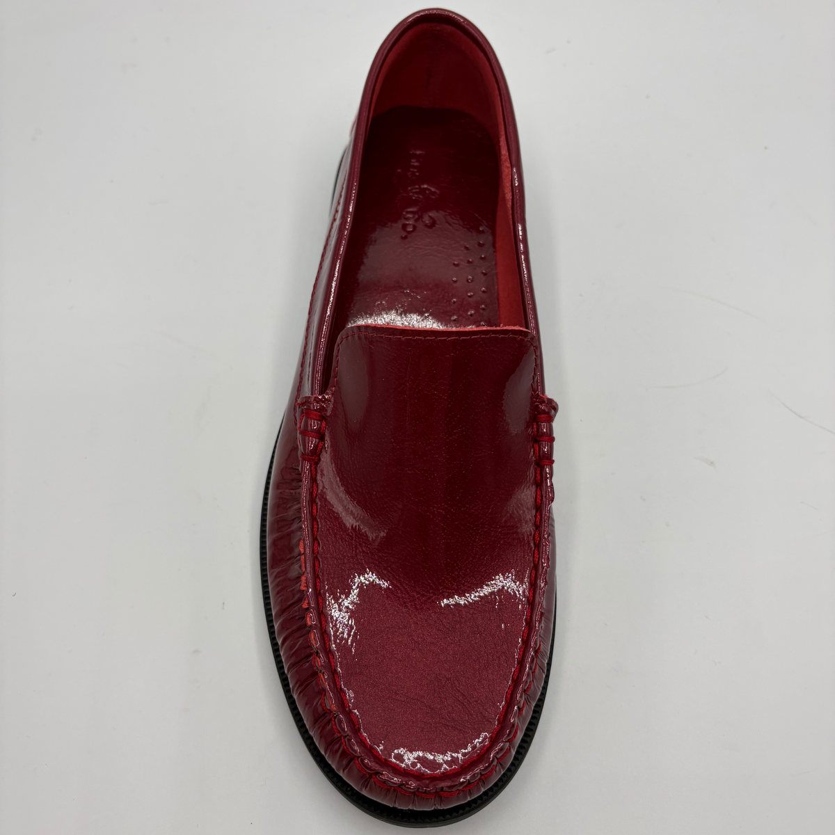 A single glossy red patent leather loafer shown from a top-down view on a plain white background.