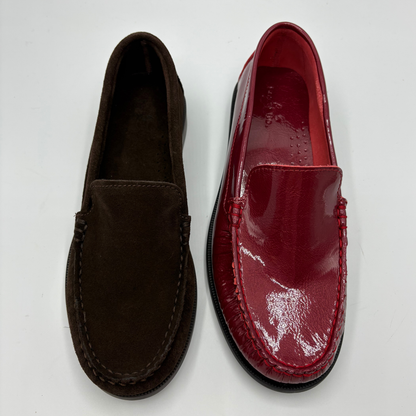 Two slip-on moccasin-style loafers shown side by side on a plain white background. The left shoe is dark brown suede, and the right shoe is glossy deep red patent leather.