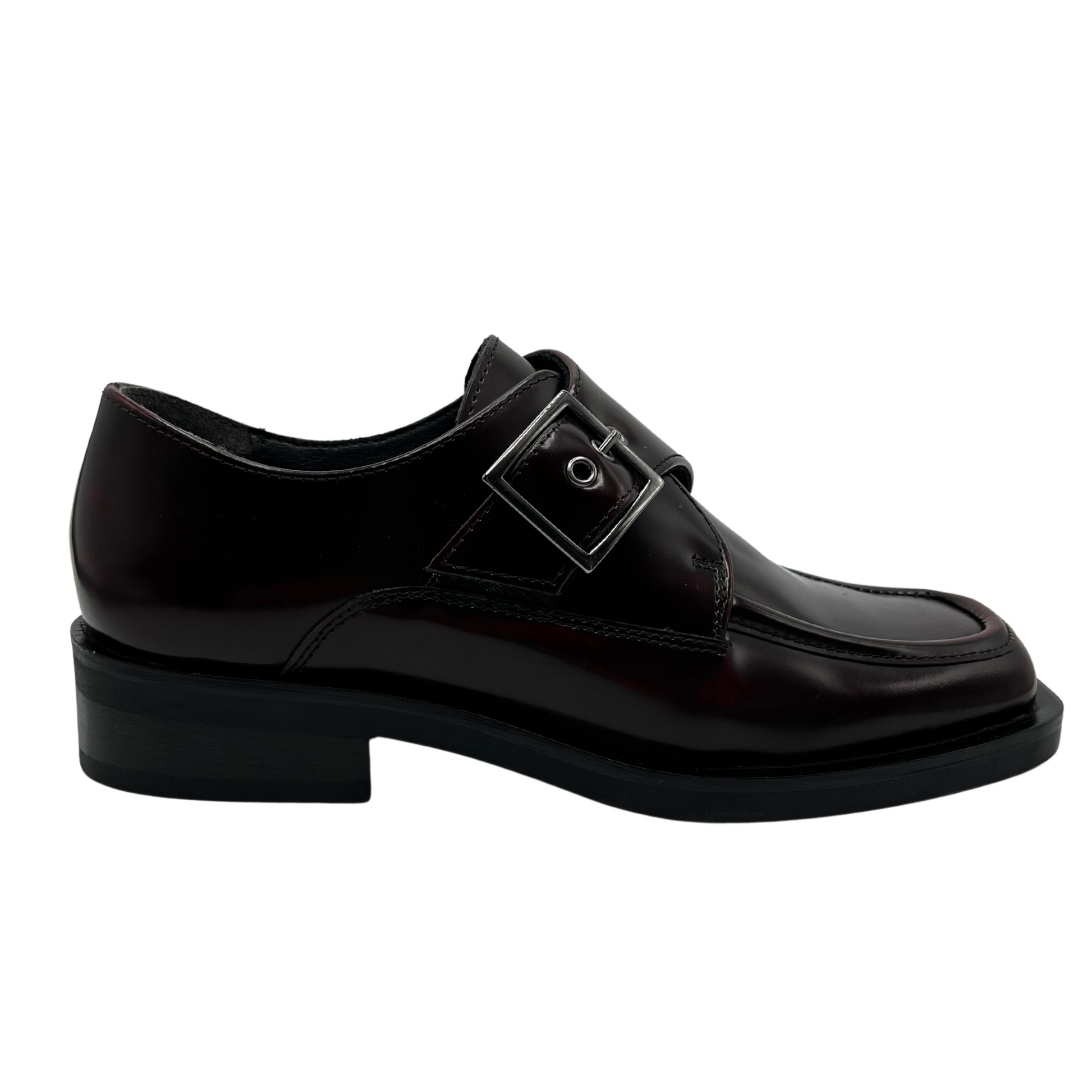 Right facing view of bordo leather loafer with silver buckle on upper, low heel and leather lining.