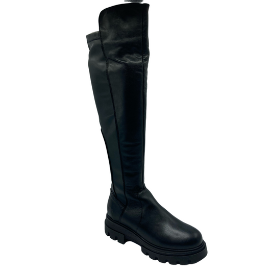 45 degree angled view of black leather thigh high boots with platform rubber sole and rounded toe