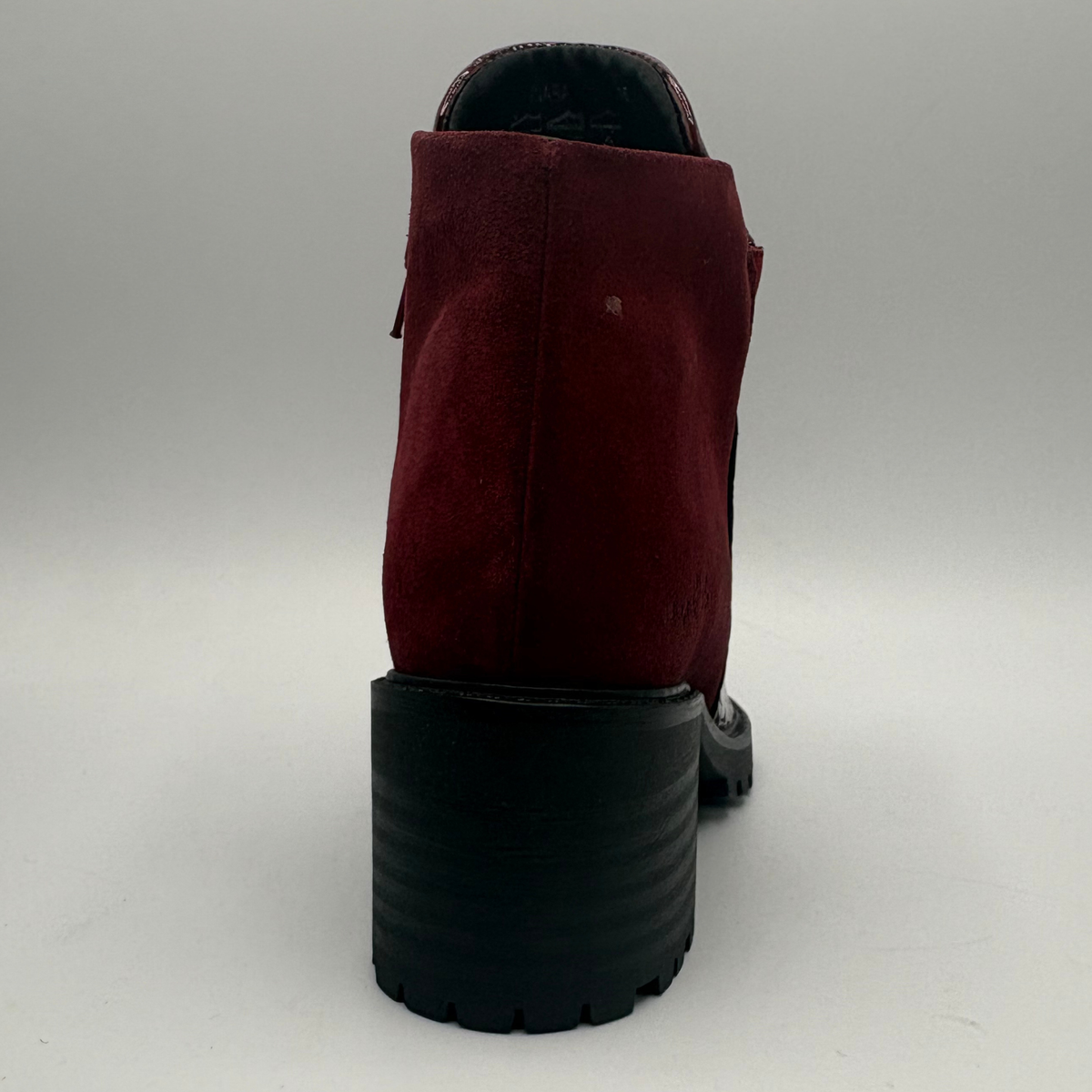 Back view of a short boot with a red croc front panel and a sturdy block heel