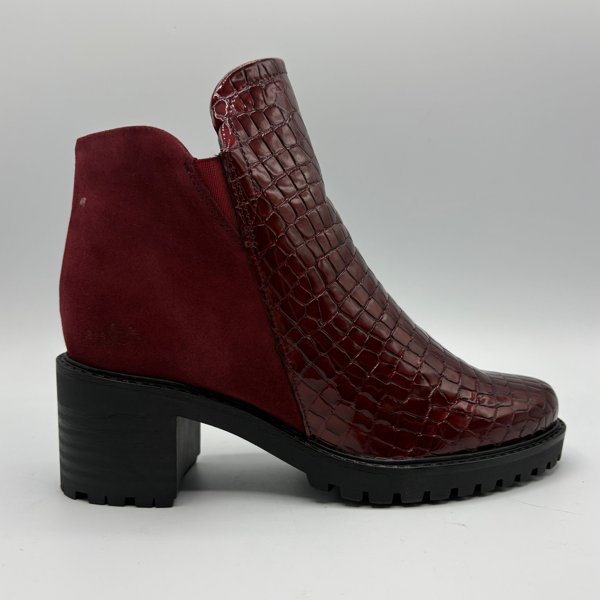 Right facing view of a short boot with a red croc front panel and a sturdy block heel