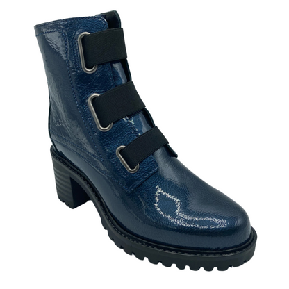 45 degree angled view of short blue patent leather boot with thick black sole and black elastic up the shaft