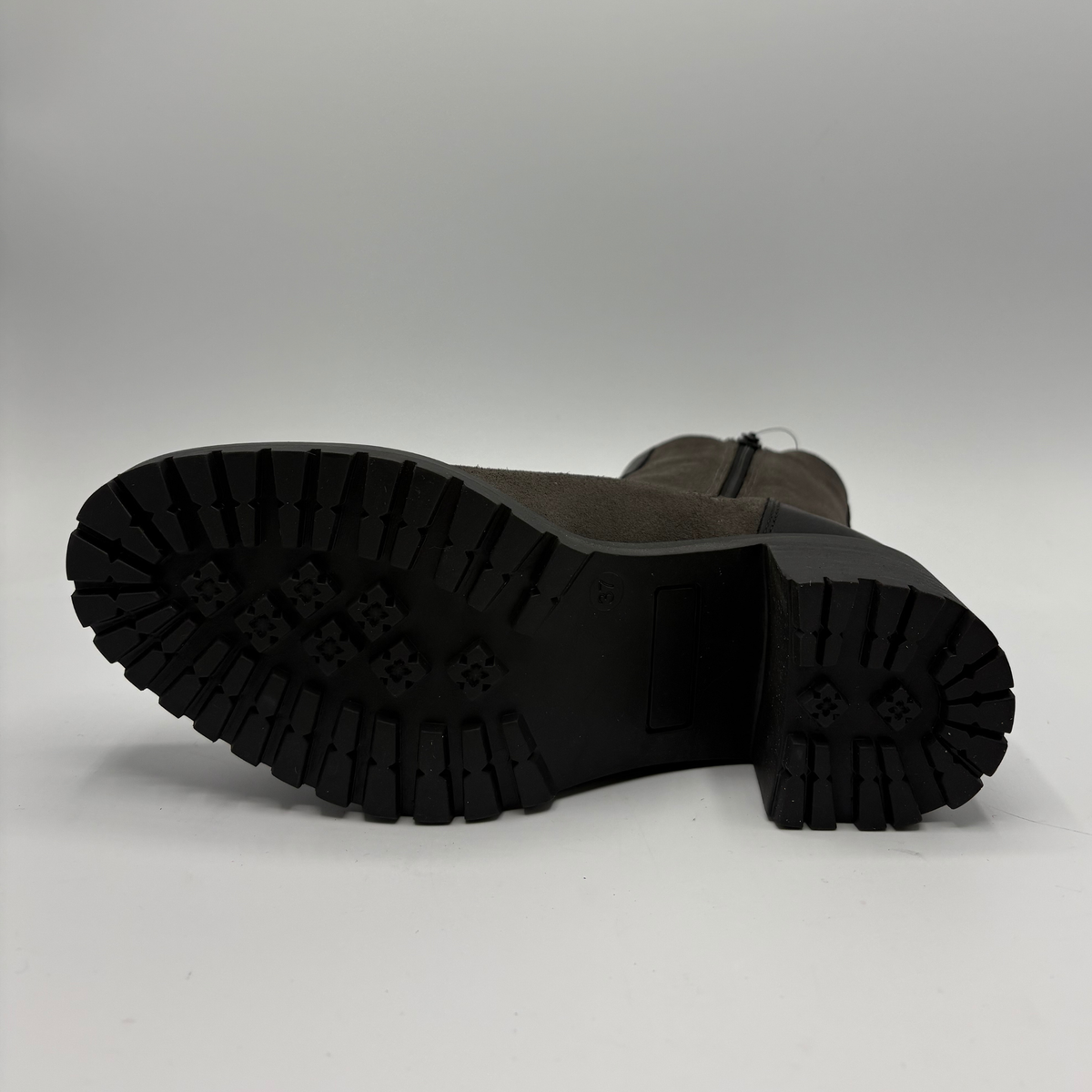 Bottom view of a two toned black short boot with a stacked heel and rounded toe