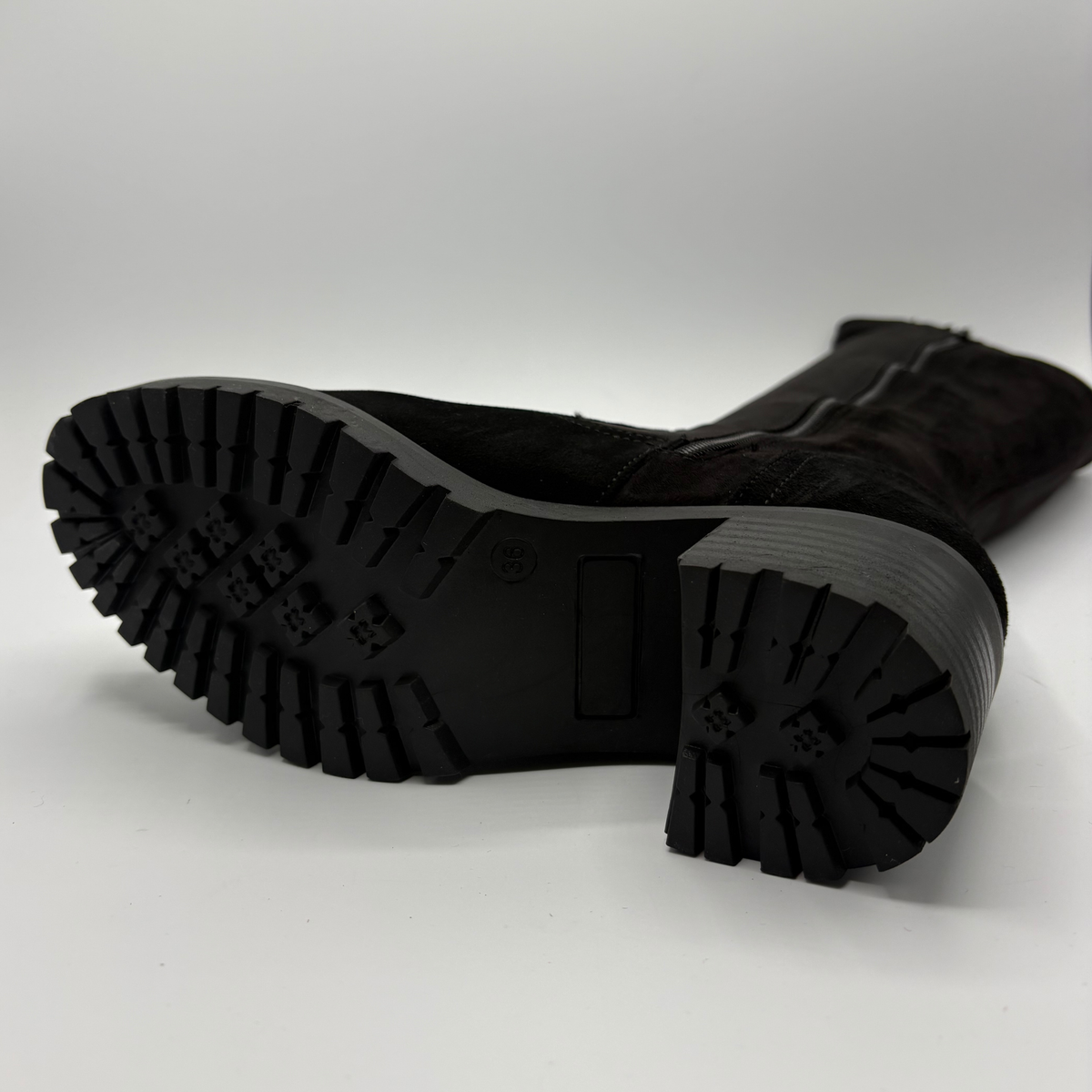 Bottom view of a black tall boot with a side zipper and a chunky heel