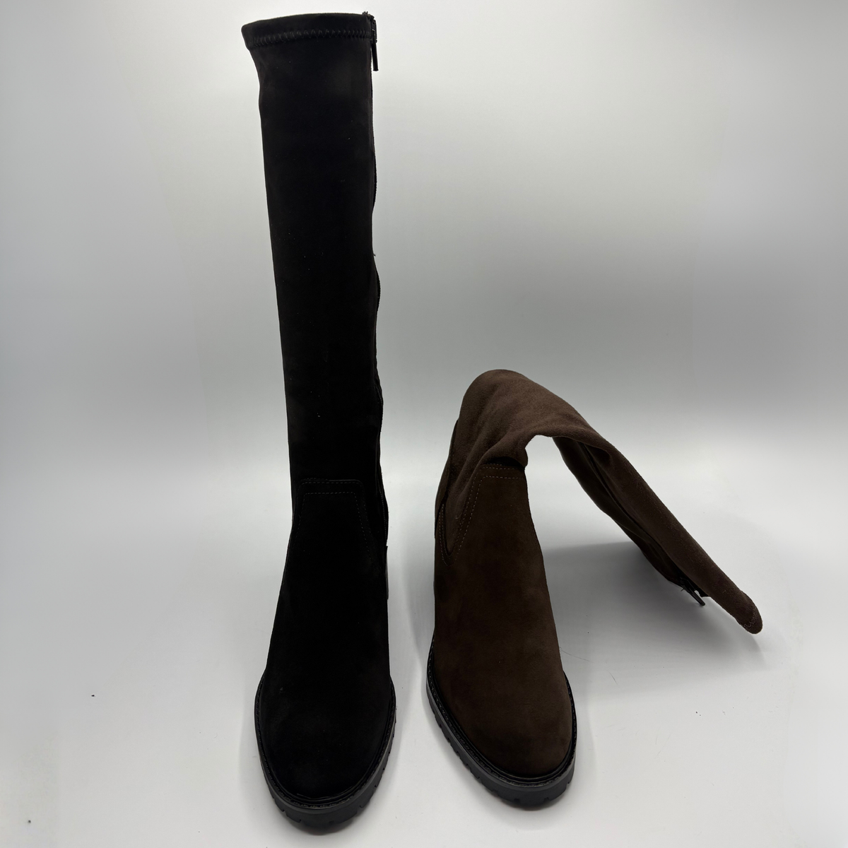 Front view of a black tall boot beside a brown tall boot. Both have a side zipper and a rounded toe