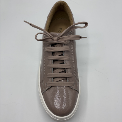 Brown sneaker with white sole on a light gray background