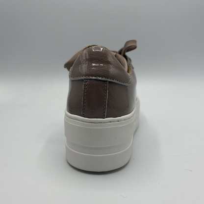 Brown sneaker with a white sole on a gray background