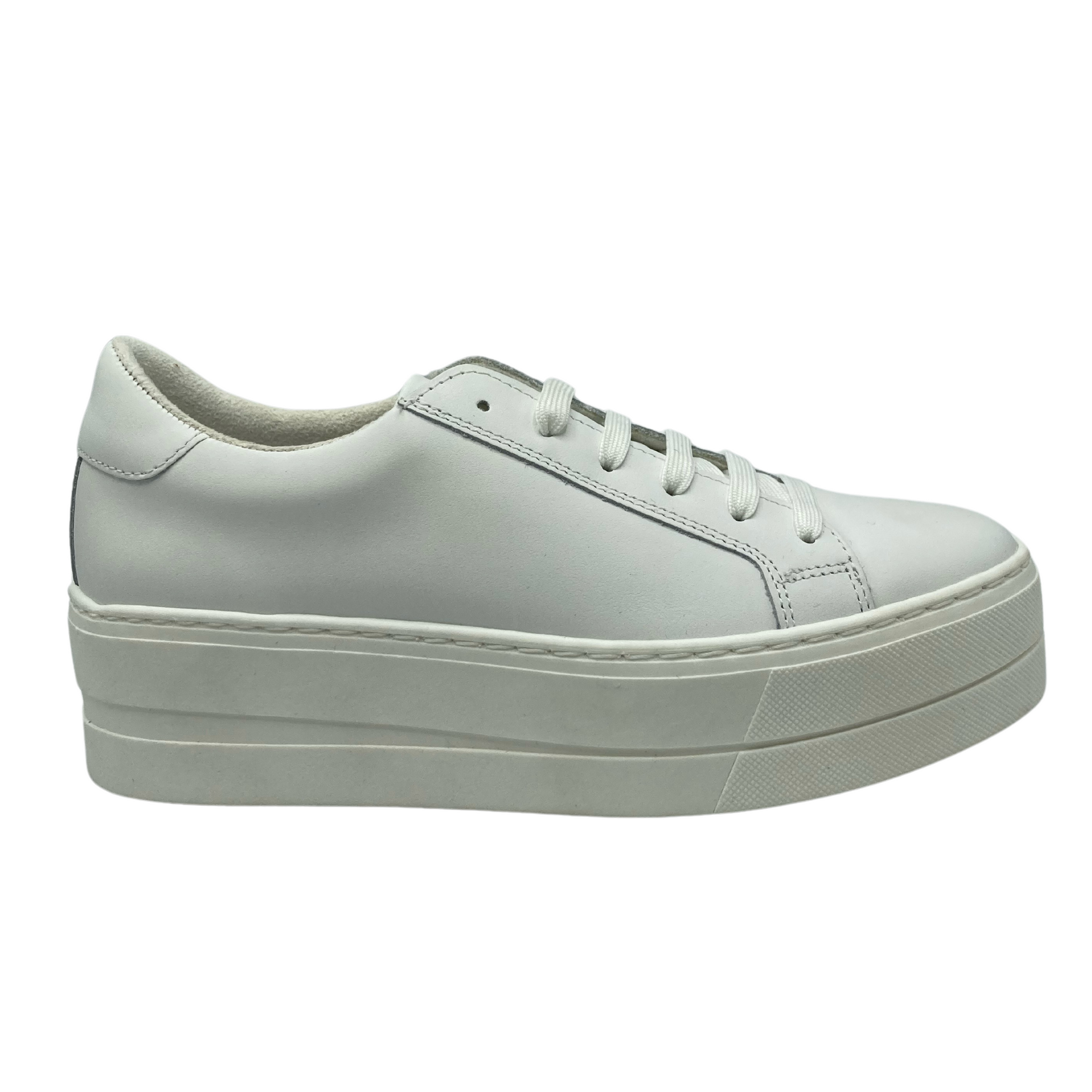 Right facing view of white leather sneaker with 2" rubber platform sole