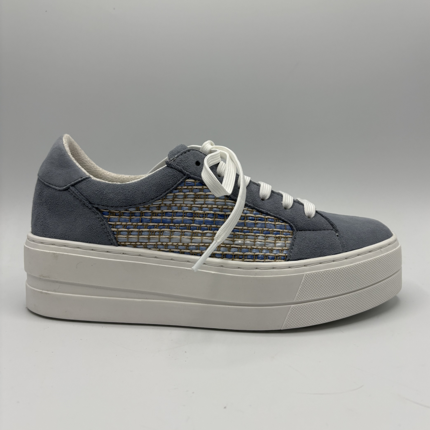Navy blue sneaker with white laces on a gray background