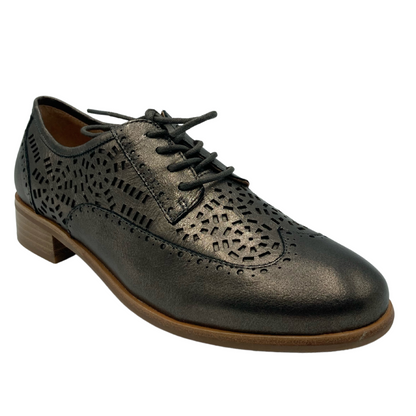 45 degree angled view of grey brown leather shoe with decorative cut outs and brown sole