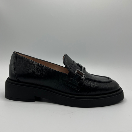 Black leather loafer shoe on a light gray background