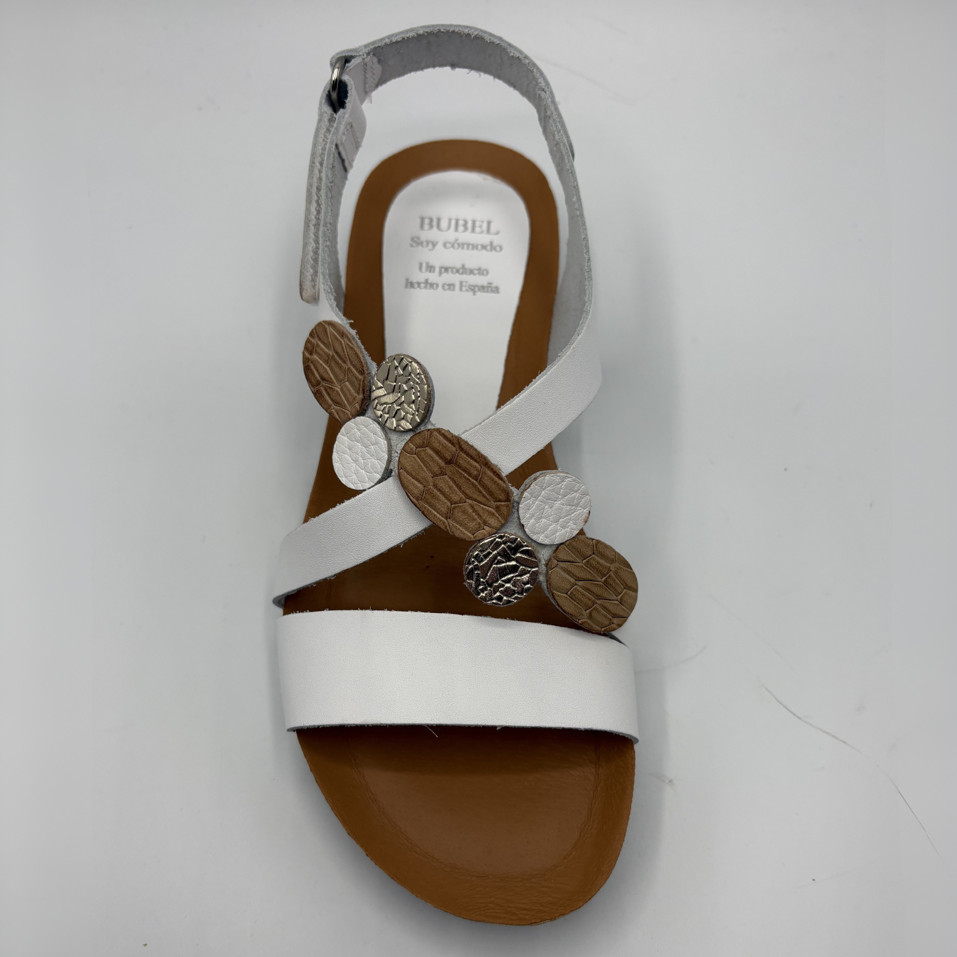 White sandal with decorative elements on a white background