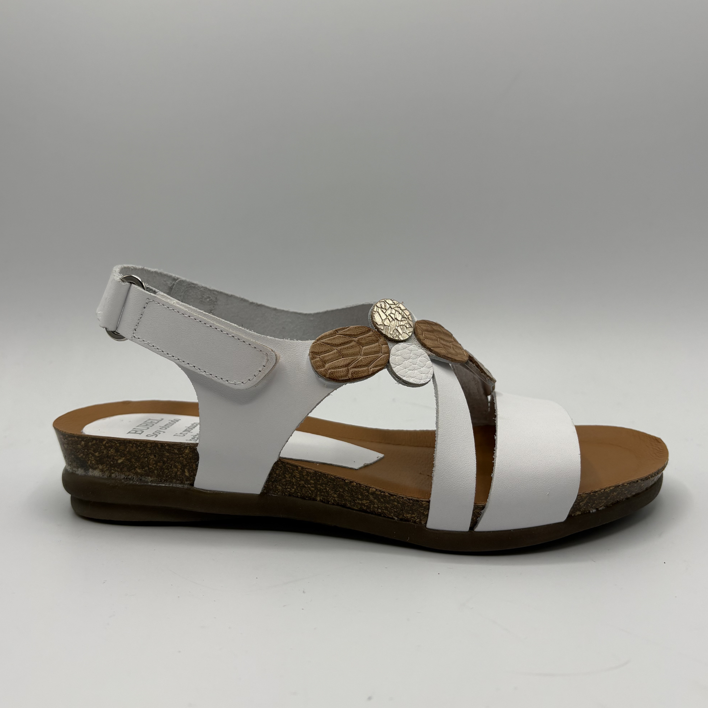 White sandal with brown accents on a gray background