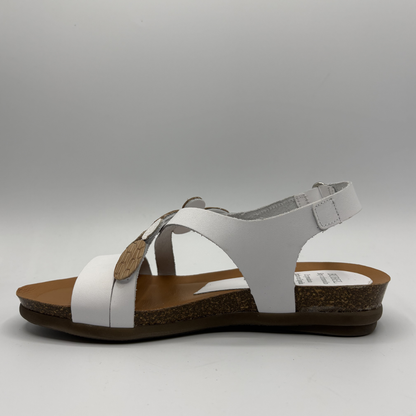 White sandal with brown sole on a gray background