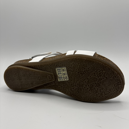Brown sandal with white straps on a gray background