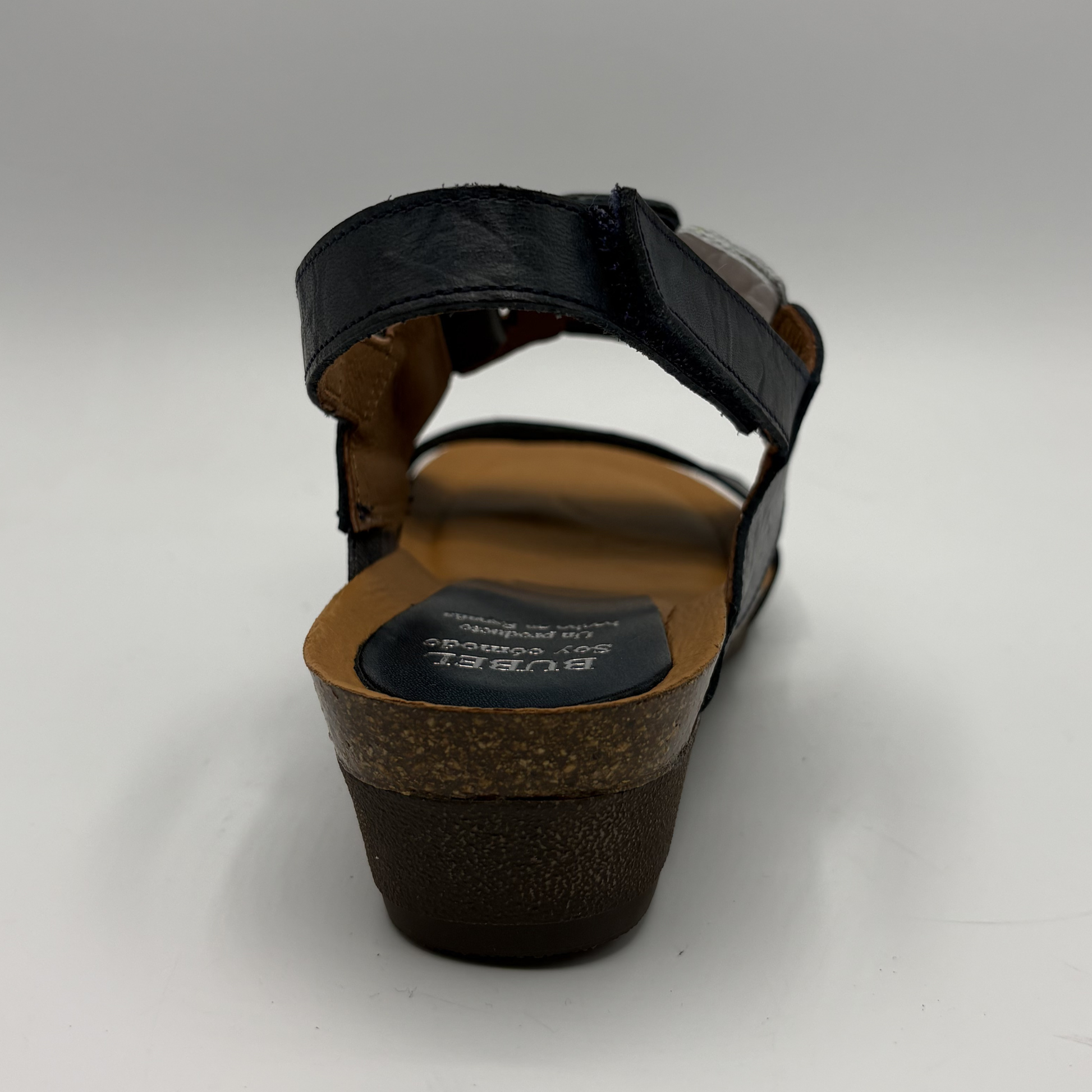 Black sandal with brown sole on a white background