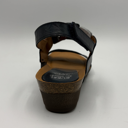 Black sandal with brown sole on a white background