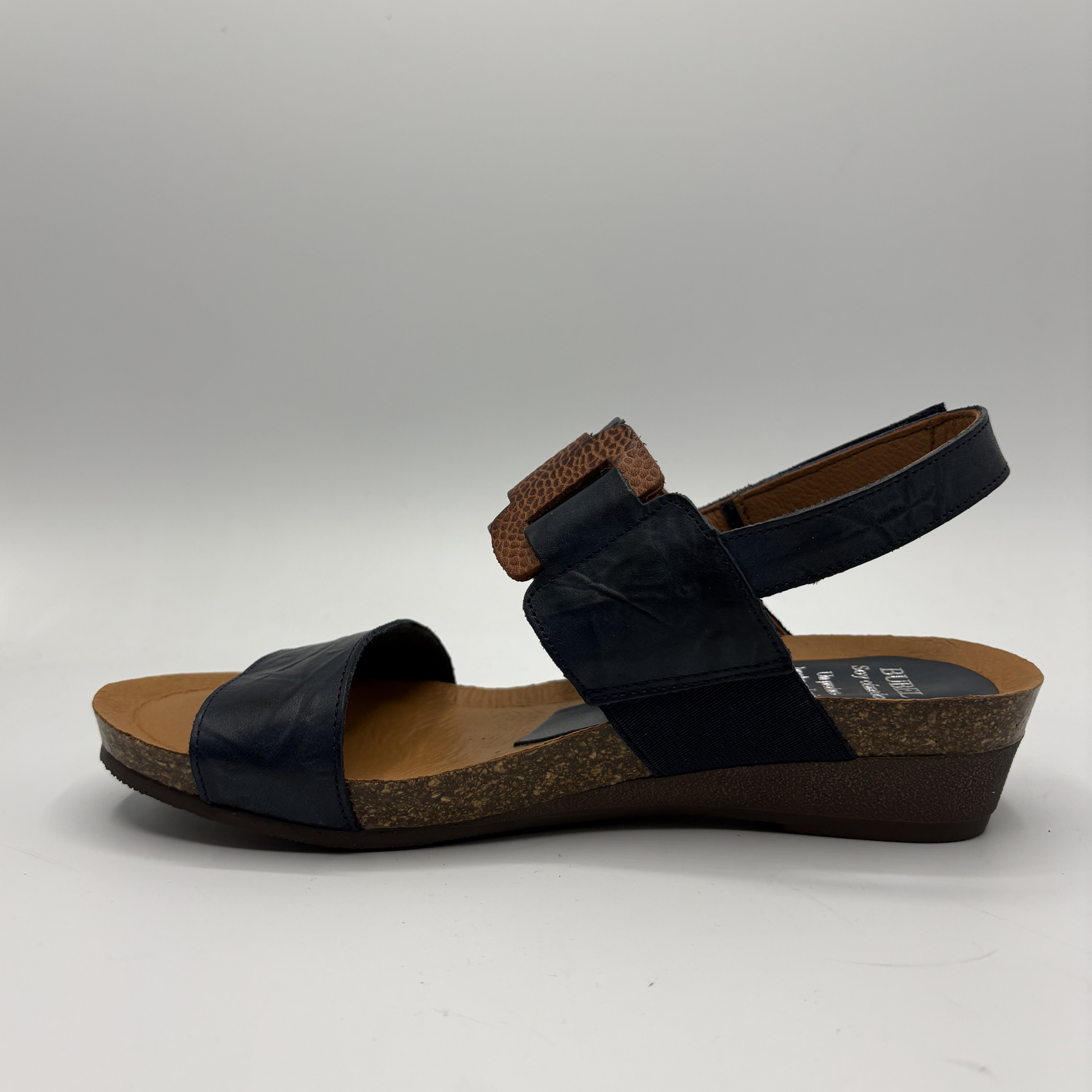 Black sandal with cork sole on a gray background