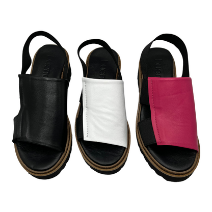 Top down view of 3 sandals. One black, one white and one hot pink