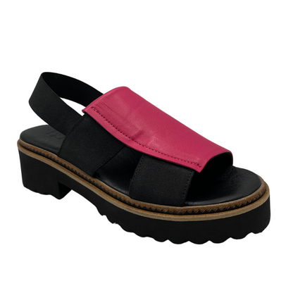45 degree angled view of hot pink and black sandal with chunky sole and elastic straps