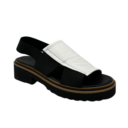 45 degree angled view of white and black sandal with black straps and chunky outsole