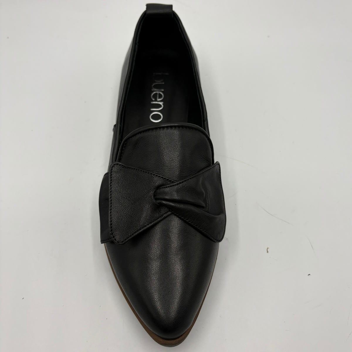 Top view of a black leather loafer with a bow accent on the toe box