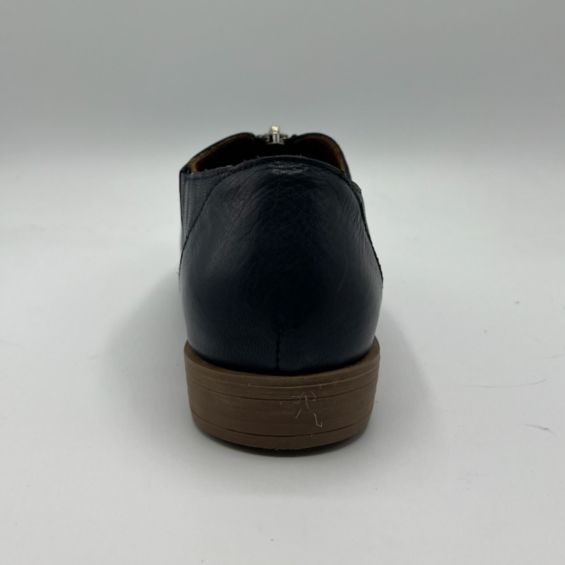 Navy leather shoe with brown sole on a white background