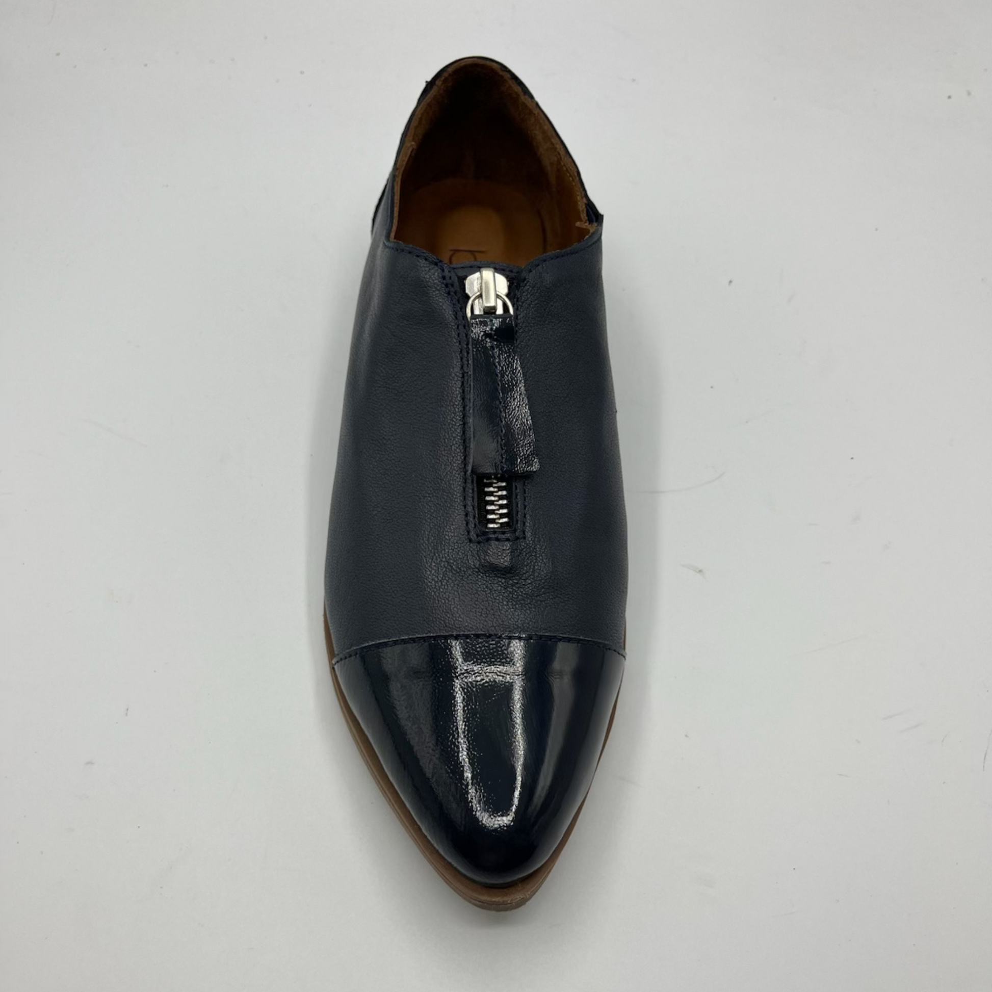 Navy leather shoe with a zipper on a light gray background