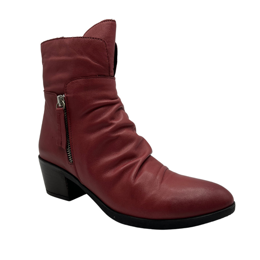 45 degree angled view of red leather short boot with a slouchy rouched upper, side zipper closure, 2 inch chunky heel and pointed toe