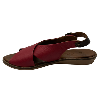 Left facing view of red leather sandal with cross strap design, slight wedge heel and brown slingback strap