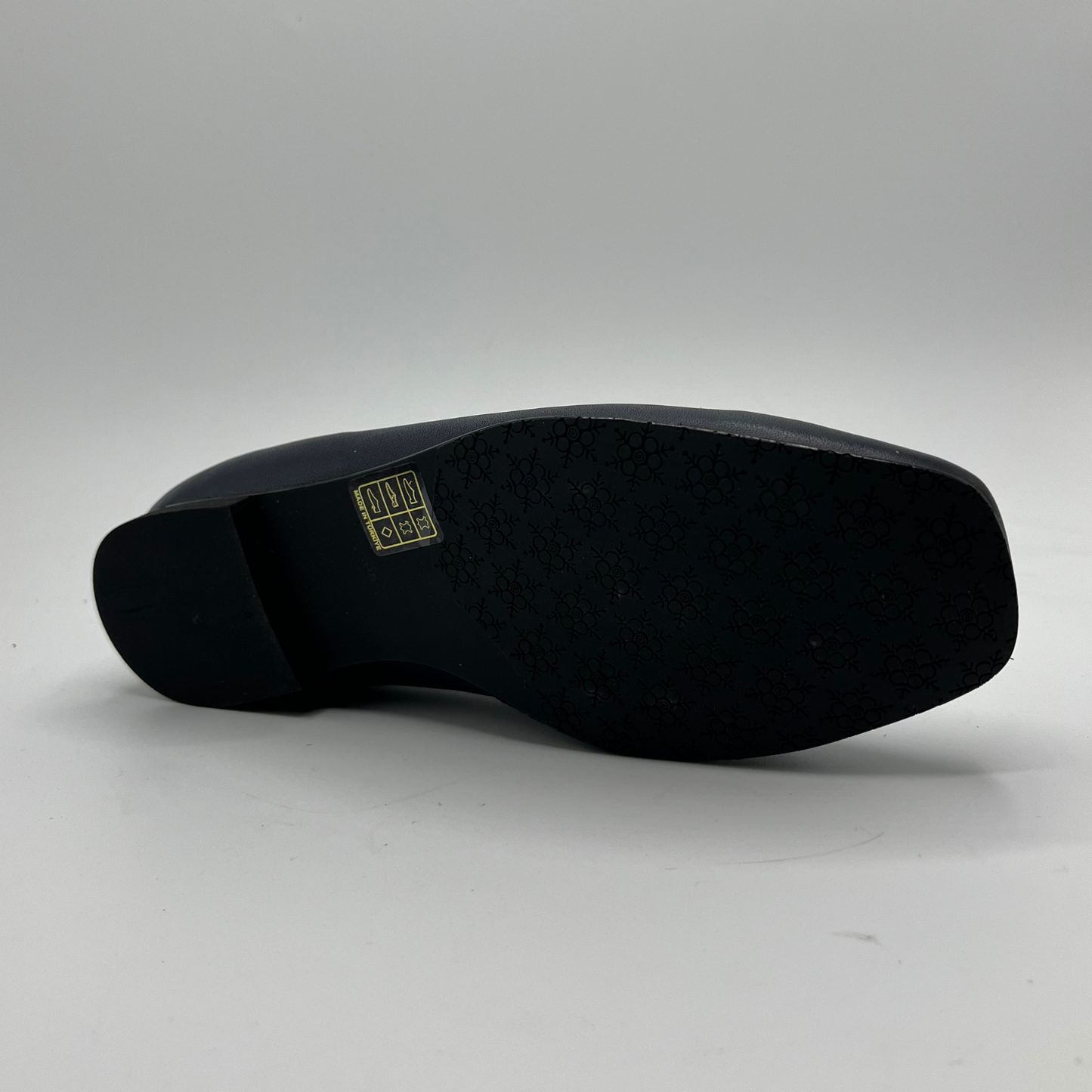 Navy shoe sole with a visible brand logo on a gray background