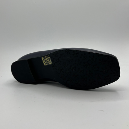 Navy shoe sole with a visible brand logo on a gray background