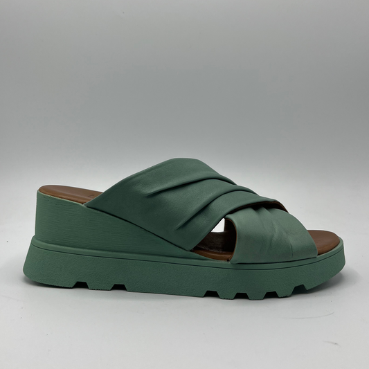 Right facing view of a leather slip on sandal in seafoam. Rouched cross strapped design and a wedge heel.