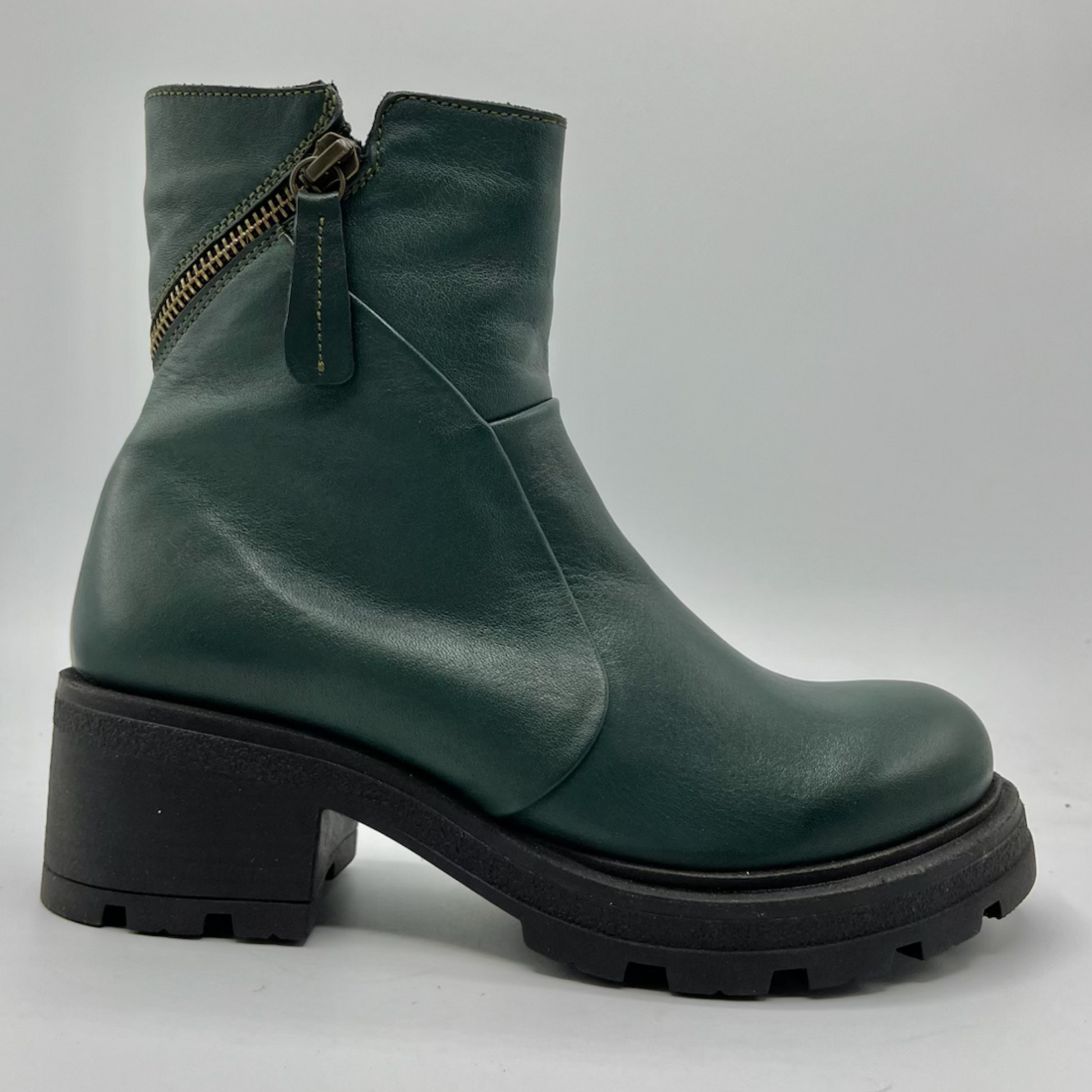 Green leather boot with a zipper on a gray background