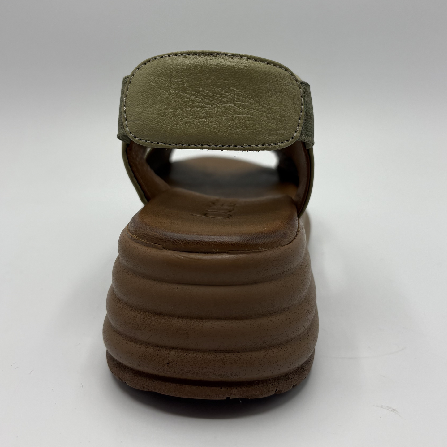 Brown sandal with green strap on a white background